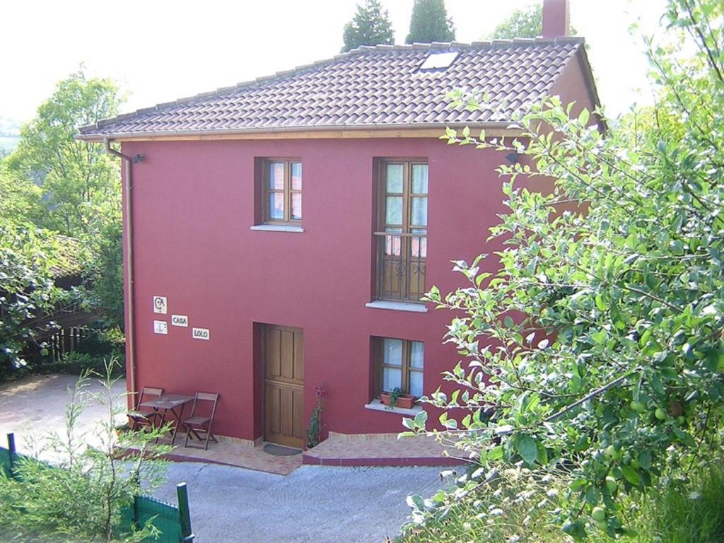 a red house with two windows and a door at Casa Lolo de Villaviciosa in Camoca