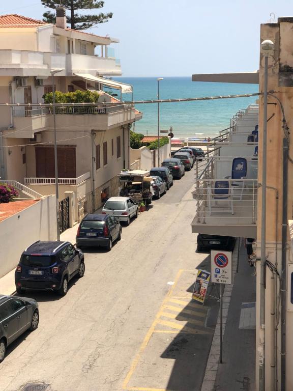 uma fila de carros estacionados numa rua junto à praia em Il Mare A Due Passi em Marina di Ragusa