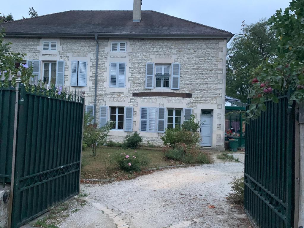 uma velha casa de tijolos com um portão em frente em Chambres d'hôtes dans une maison de caractère em Mussey-sur-Marne
