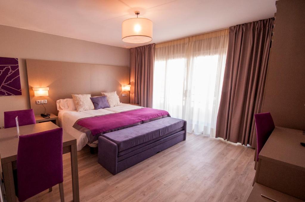 a bedroom with a large bed and a large window at Hotel El Faro Marbella in Marbella