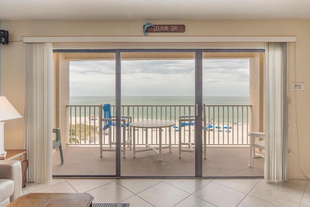 Cette chambre dispose d'une porte coulissante en verre offrant une vue sur l'océan. dans l'établissement 409 Beach Place Condos, à St. Pete Beach