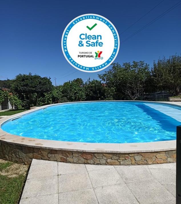 a large swimming pool with a sign that reads clean and safe at Casa da Belavista in Trofa