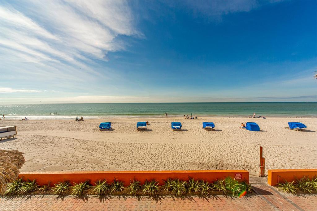 a beach with blue beach chairs and the ocean at #103 Las Brisas Condo in St. Pete Beach
