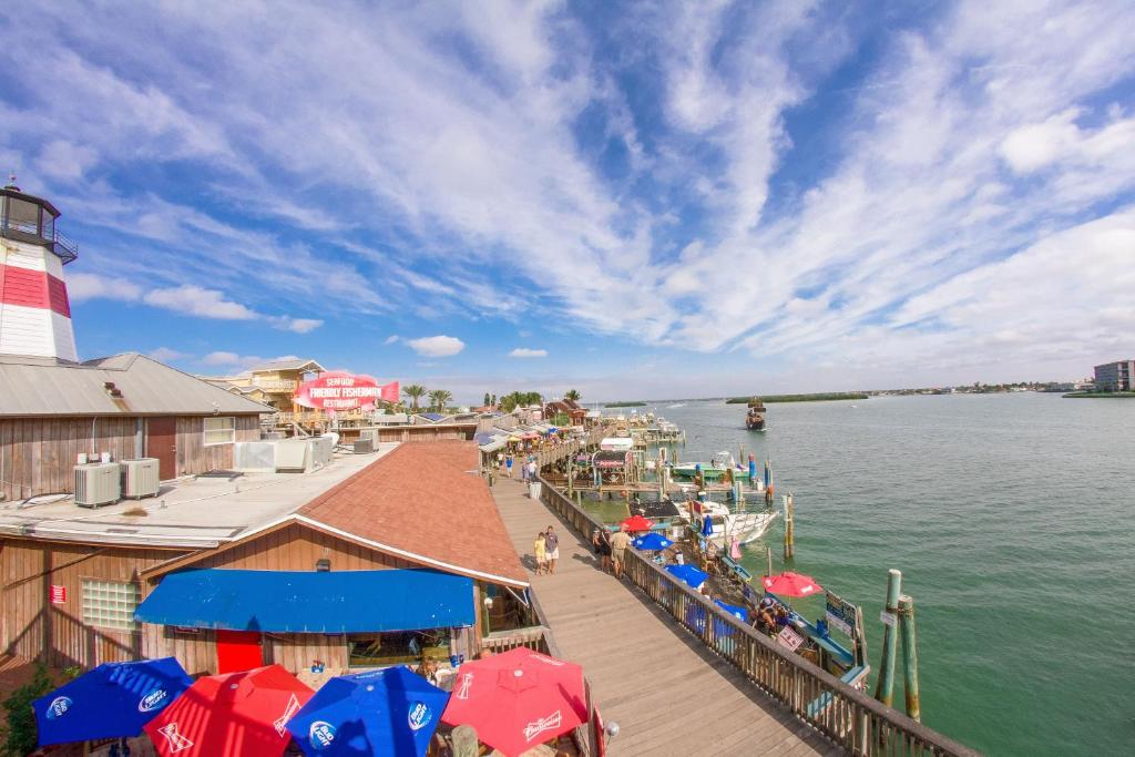 a dock with umbrellas and a lighthouse on the water at 201 Sandy Shores Condos in St. Pete Beach