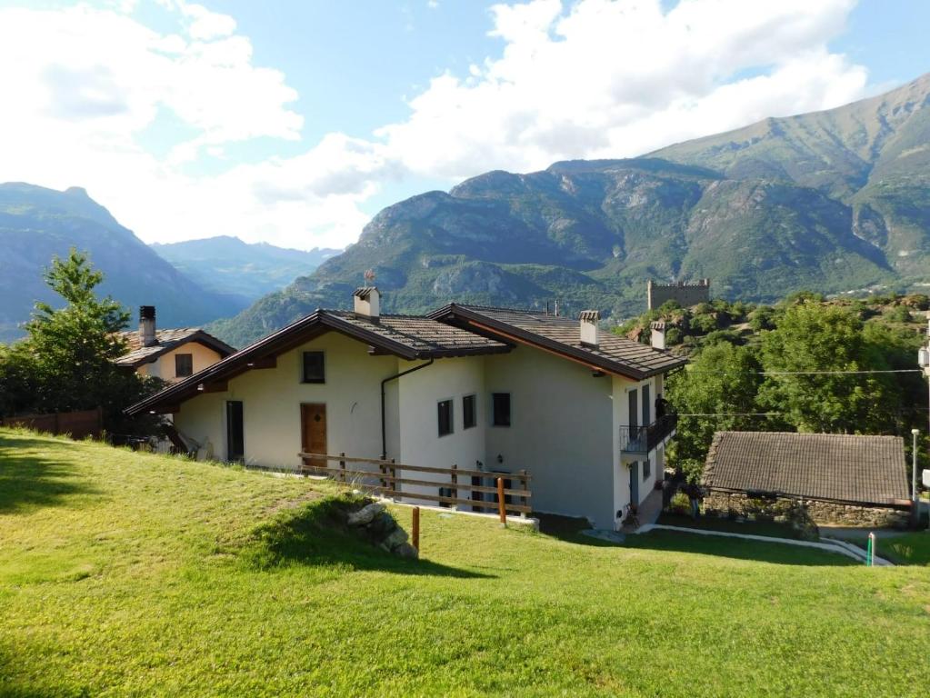 una casa en una colina con montañas en el fondo en La Maison de Joanna, en Châtillon