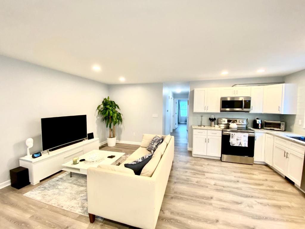 a living room with a white couch and a kitchen at The Longmont Luxury Condo in the heart of providence in Providence