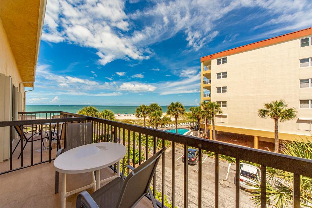 a balcony with a table and chairs and a view of the beach at 346 Surf Song Resort in St Pete Beach
