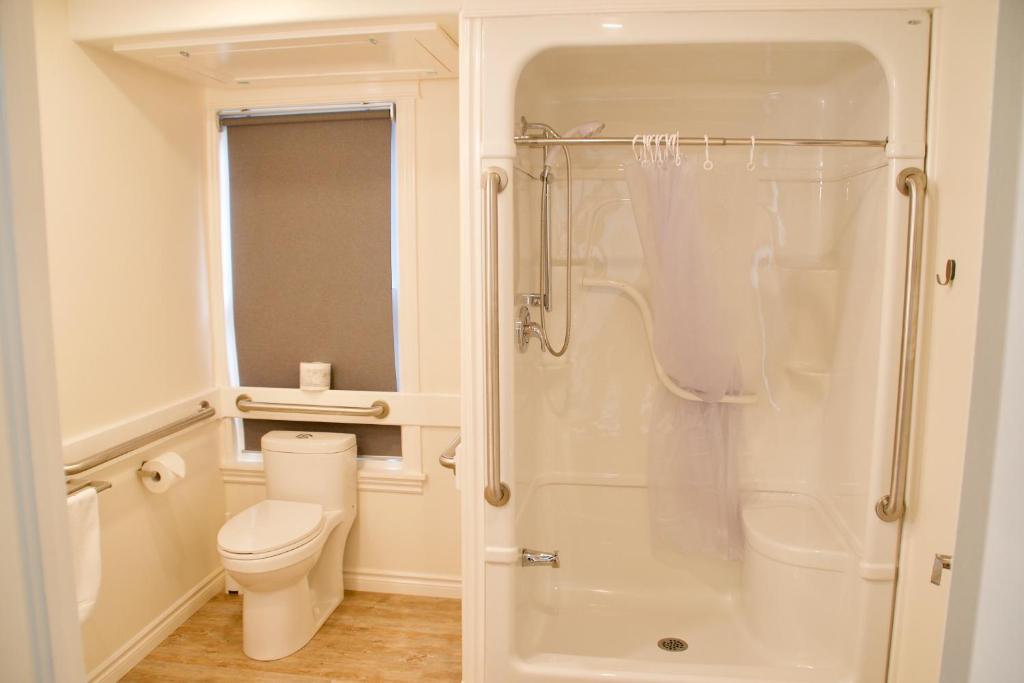 bagno bianco con servizi igienici e doccia di Rum Runner Inn a Lunenburg