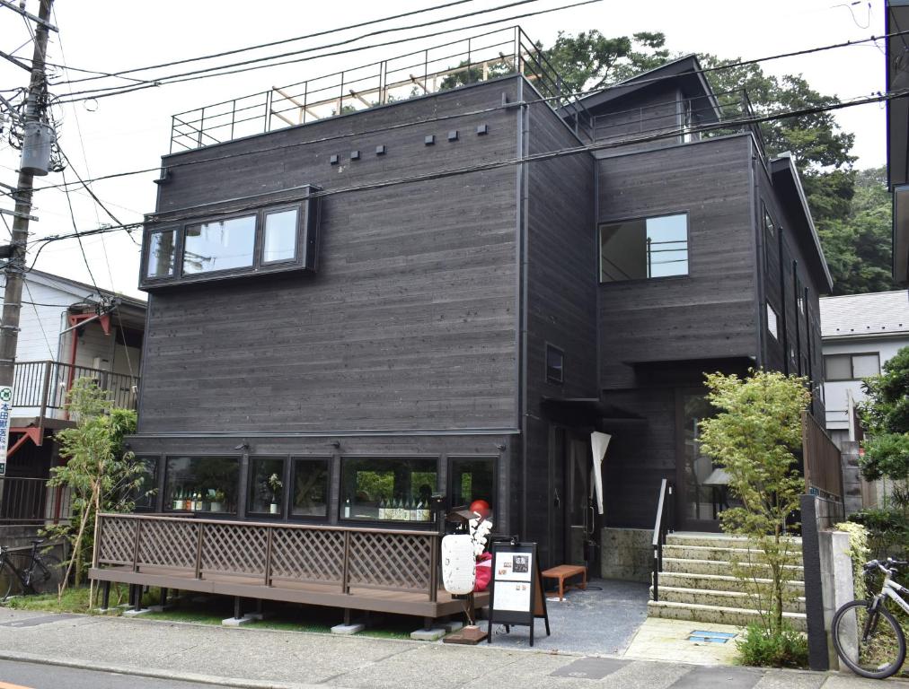 a black house with a bench in front of it at B&B KAMAKURA in Kamakura
