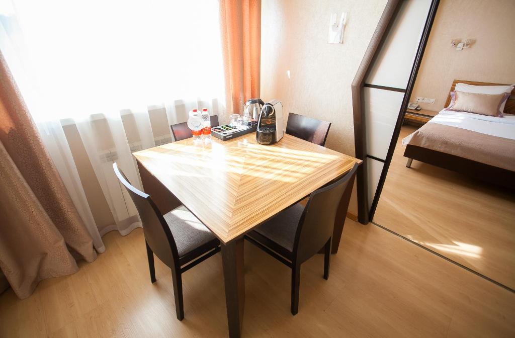 a room with a table and chairs and a bed at AZIMUT Hotel Siberia in Novosibirsk