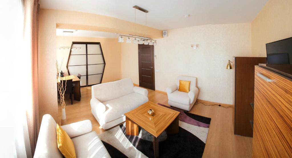 a living room with a white couch and a table at AZIMUT Hotel Siberia in Novosibirsk