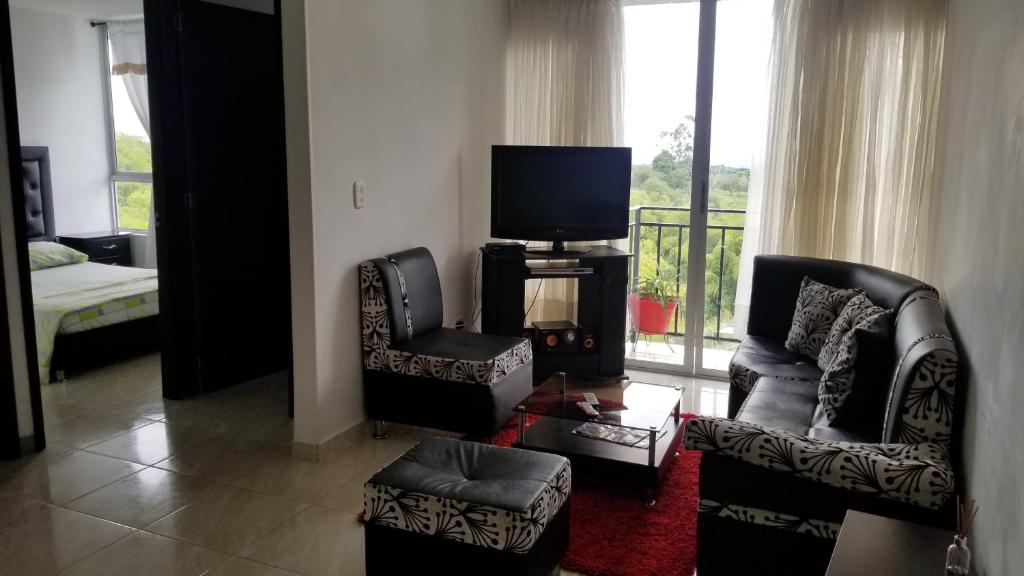 een woonkamer met 2 stoelen en een flatscreen-tv bij Apartamento Armenia, como en casa! in Armenia