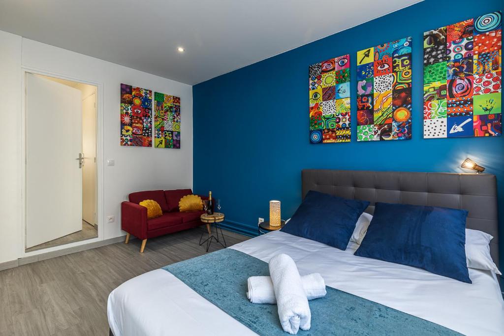 1 dormitorio con paredes azules y 1 cama con toallas en ESCAPE time - Paris en Gentilly