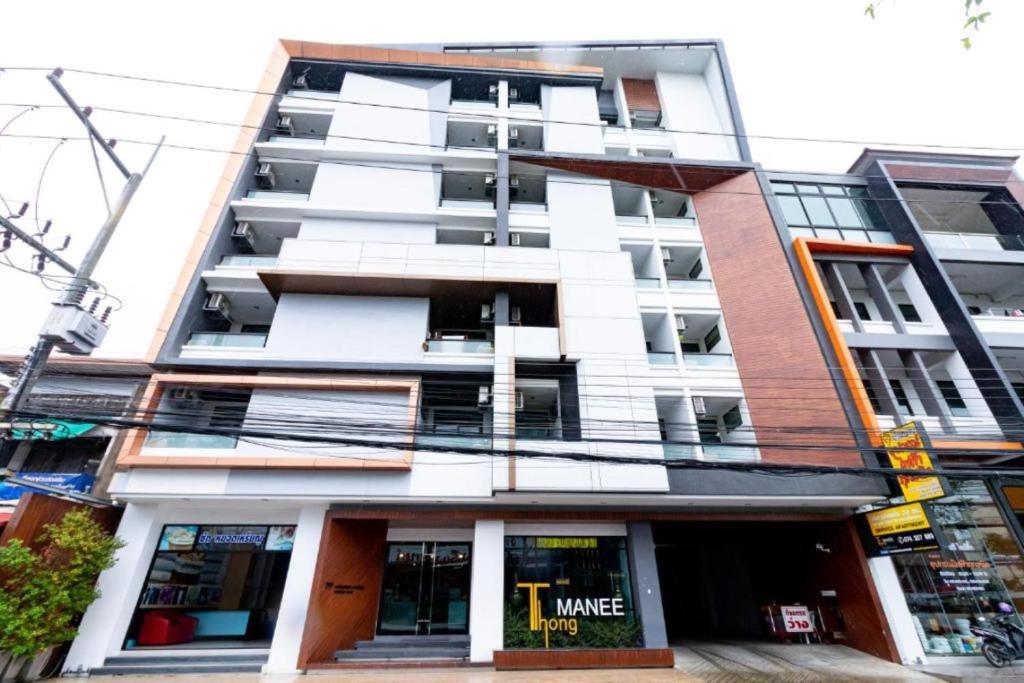 a tallartment building with a store in front of it at Thongmanee Hotel in Hat Yai