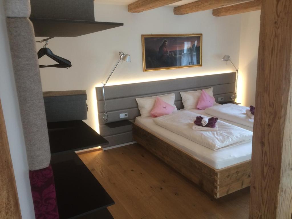 1 dormitorio con 2 camas y almohadas rosas en Zum Hirschen - hotel & gasthaus beim stöckeler en Scheidegg