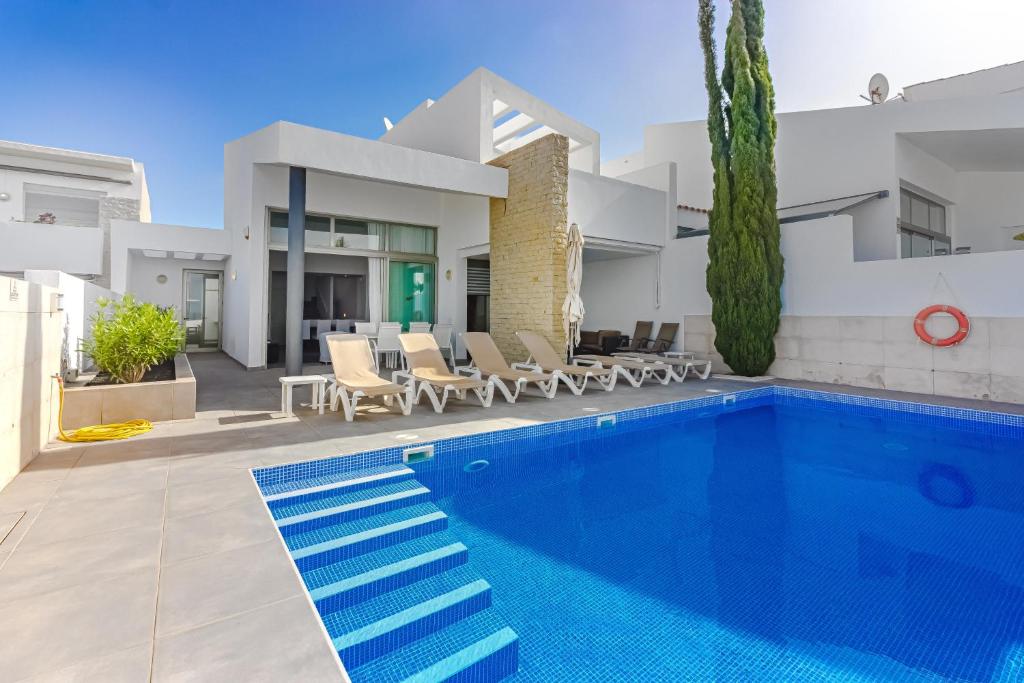 eine Villa mit einem Pool und einem Haus in der Unterkunft Villa Caterina, Luxury Villa with Heated Pool Ocean View in Adeje, Tenerife in Adeje