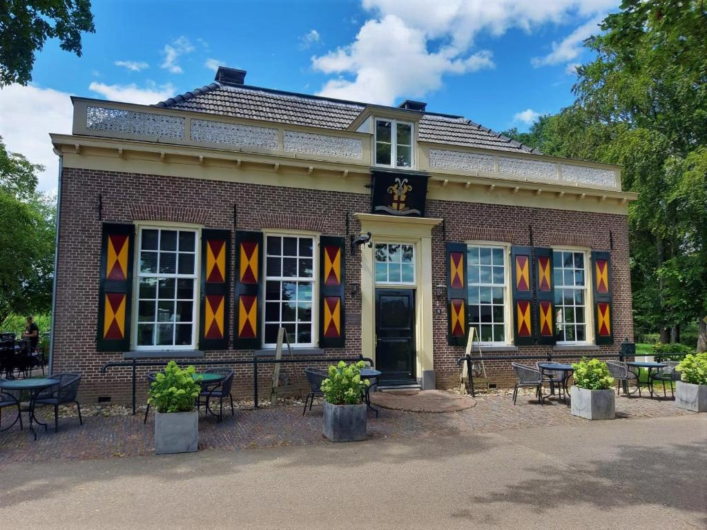 um edifício de tijolos com mesas e cadeiras em frente em Vakantiehuis Het Wapen van Heeckeren em Hummelo