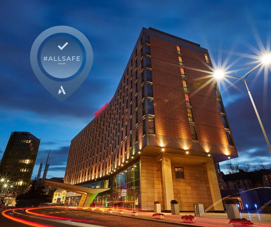 a building on a street with lights in front of it at Hotel Mercure Poznań Centrum in Poznań