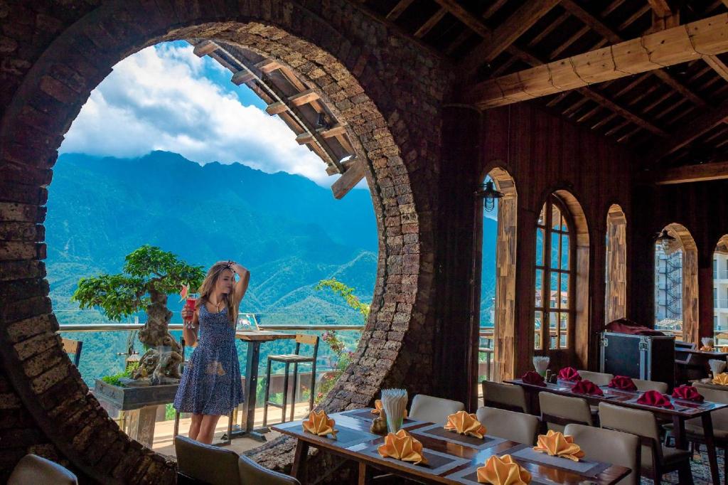 una mujer parada en un arco en un restaurante en Chau Long Sapa 2 Hotel en Sa Pa