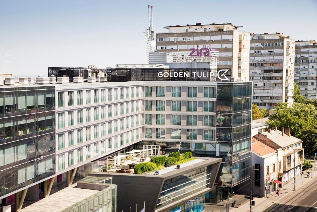 a building with a sign on top of it at Golden Tulip Zira Belgrade in Belgrade