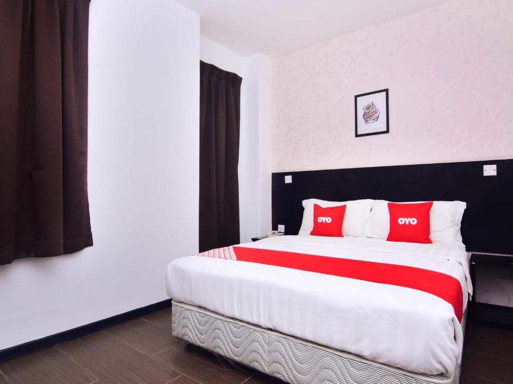 a bedroom with a large bed with red pillows at Super OYO 43959 Astana Hotel in Tawau