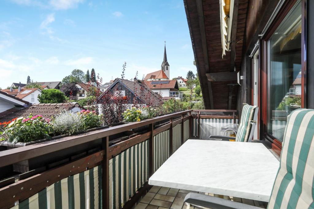 a balcony with a table and chairs and flowers at Ferienwohnung Irmi in Hergensweiler