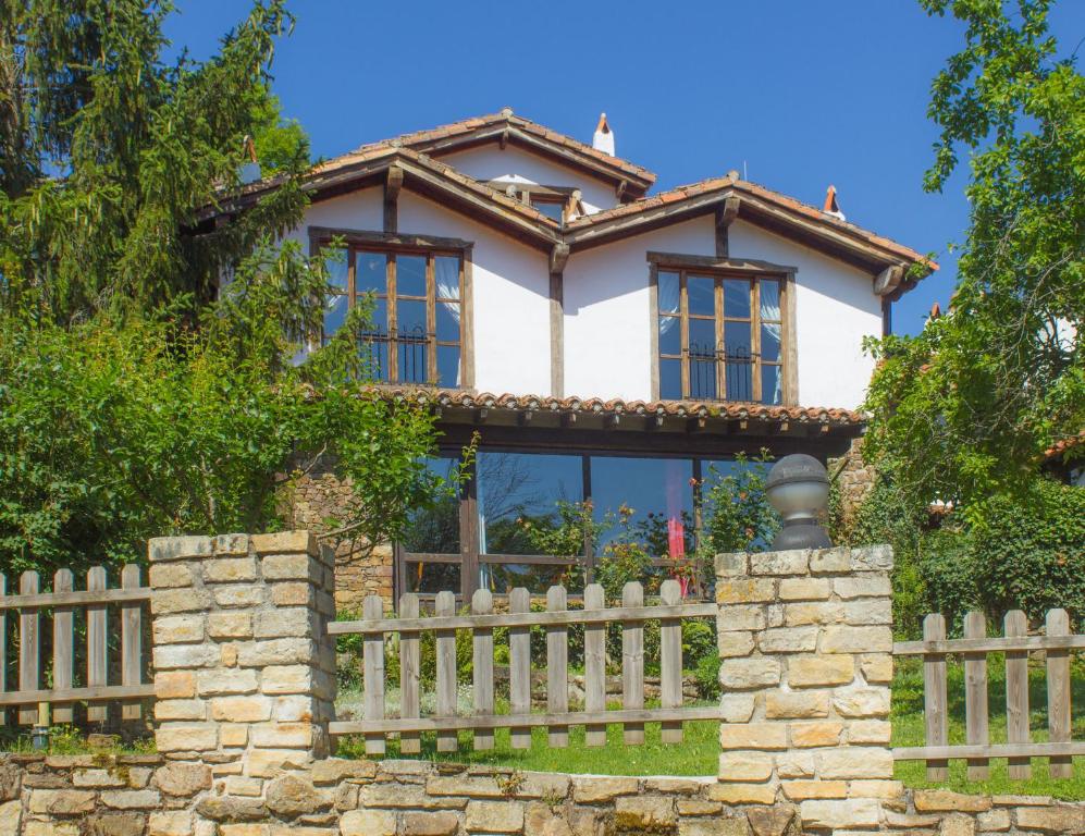 una casa con una valla delante de ella en Viviendas Rurales El Covaju en Cabezón de Liébana