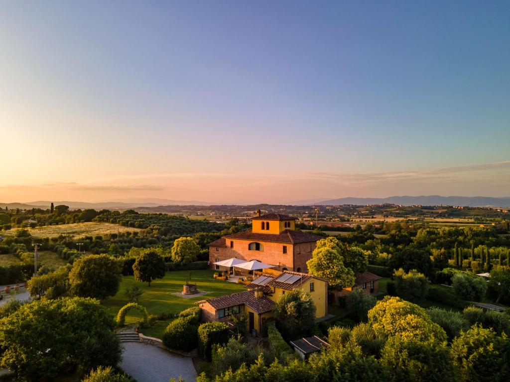 an aerial view of a villa with a sunset in the background at Il Casale Del Marchese in Bettolle