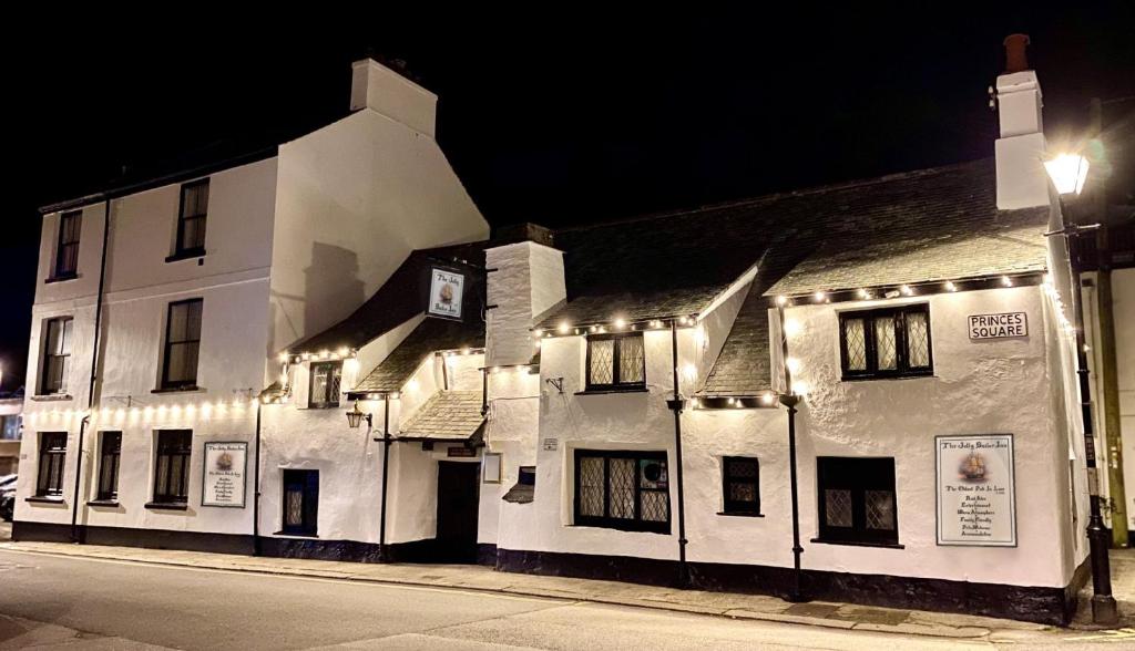a white building with lights on the side of a street at Jolly Sailor Inn in Looe