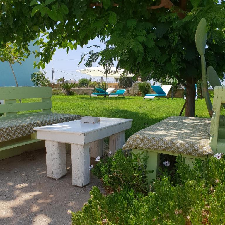 a picnic table and a bench under a tree at Hotel Aglaia in Kalamaki