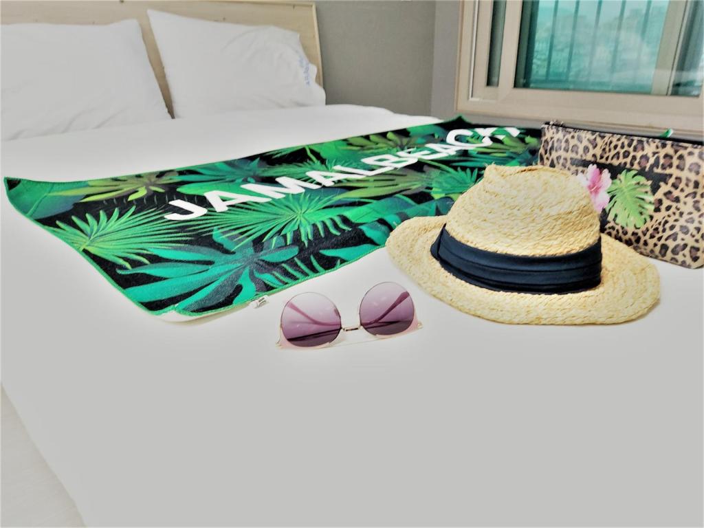 a bed with a hat and sunglasses on it at ARA Palace Hotel in Jeju