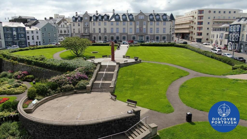 un parc en face d'un grand bâtiment dans l'établissement Portrush Atlantic Hotel, à Portrush