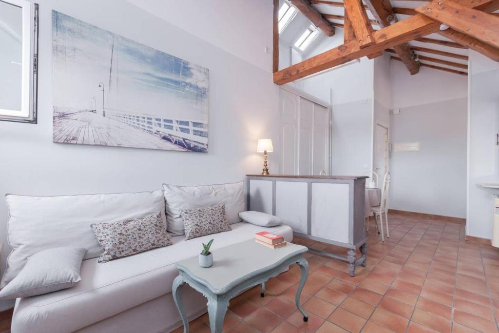 sala de estar con sofá blanco y mesa en Cozy one-bedroom penthhouse La Latina en Madrid