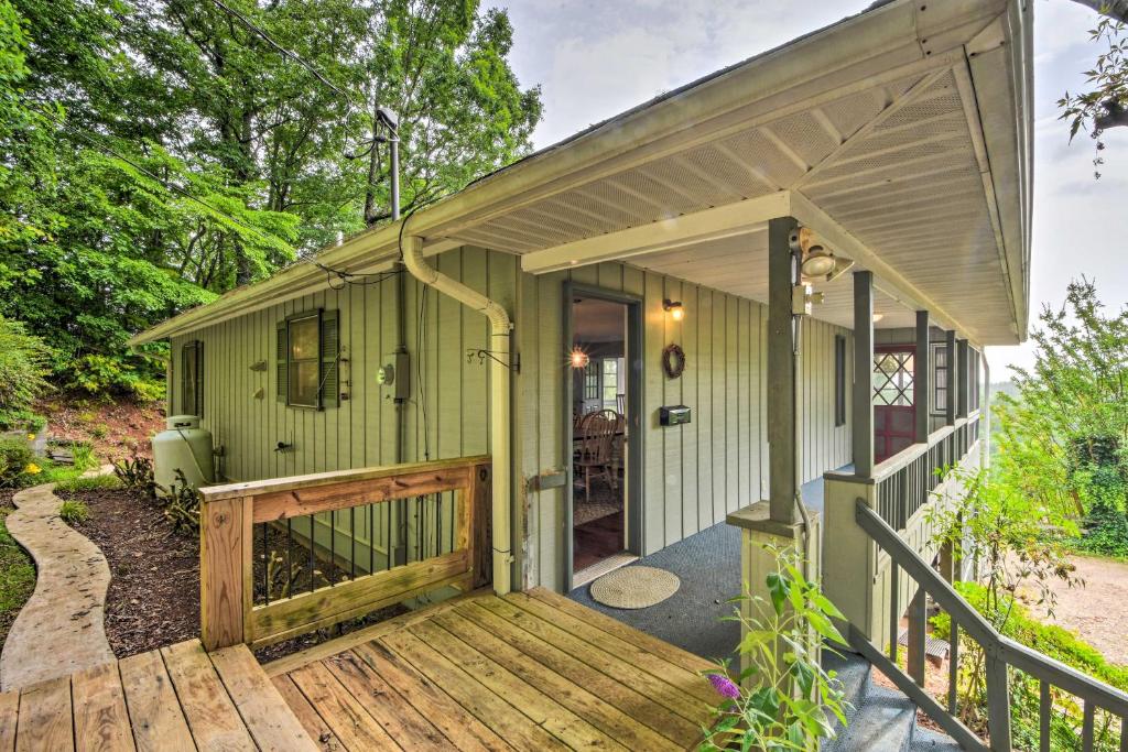 une maison verte avec une terrasse couverte et une terrasse en bois dans l'établissement Smoky Mountain Home on 20-Acre Lot with Poker Room!, à Franklin