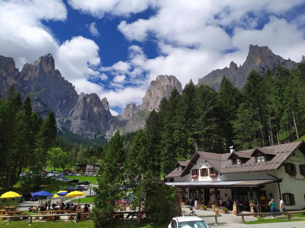 a resort with mountains in the background with a building at Hotel Cant del Gal in Fiera di Primiero