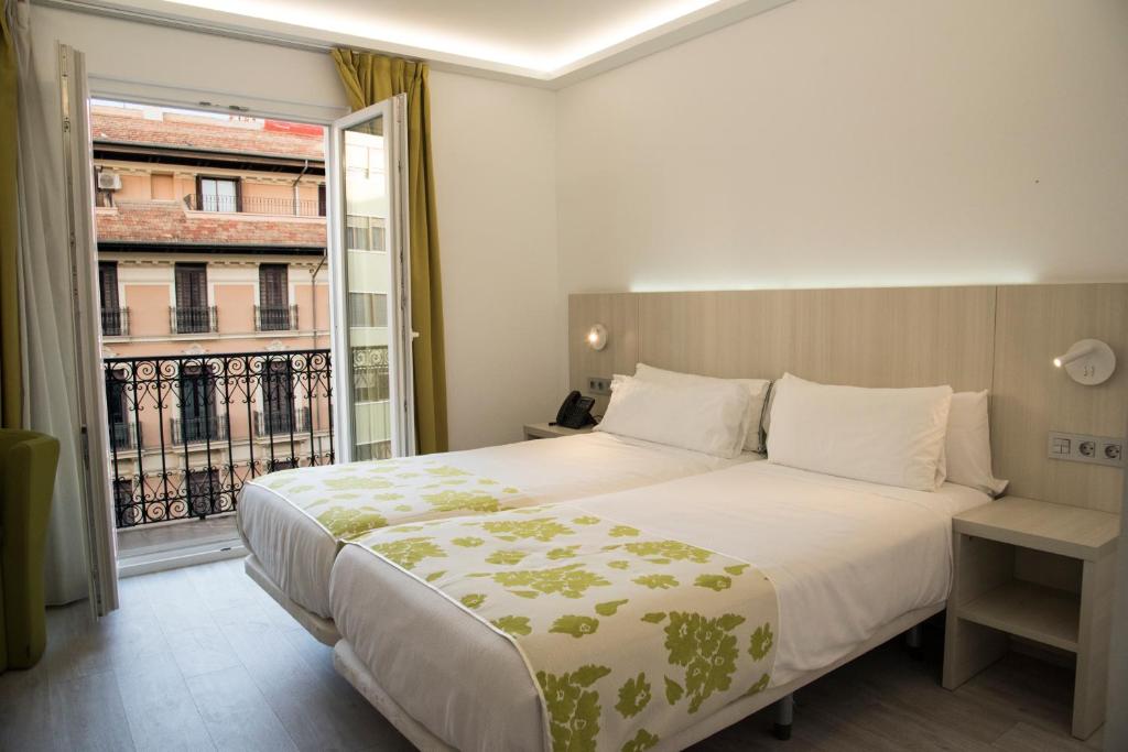 a bedroom with a large bed and a large window at Rambla Alicante Contactless in Alicante