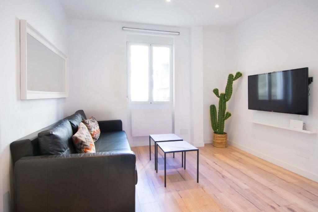 sala de estar con sofá negro y mesa en 1 bedroom 1 bathroom furnished - Salamanca - executive style - MintyStay, en Madrid