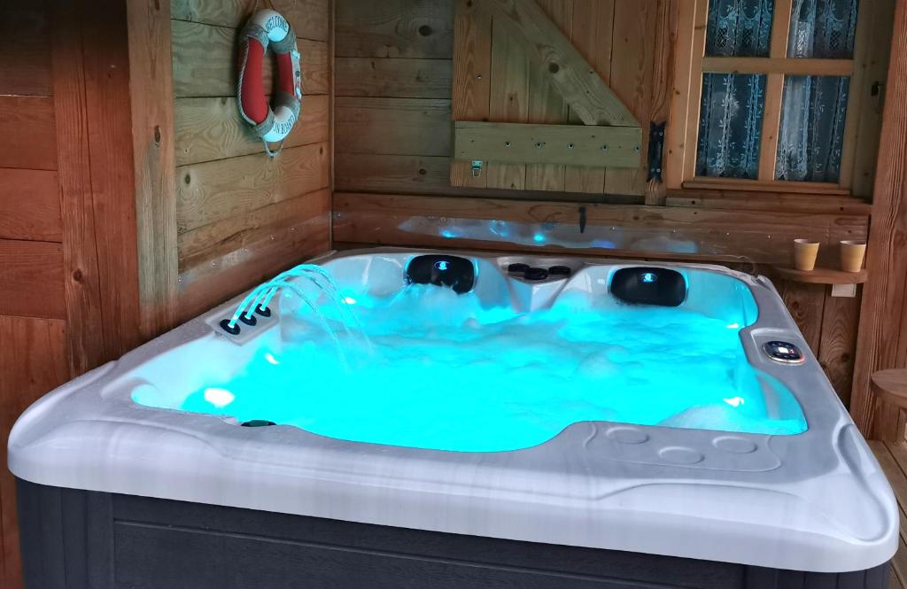 - une baignoire dans une pièce avec sauna dans l'établissement Au petit chalet avec son SPA - Escapade en amoureux !, à Cruet