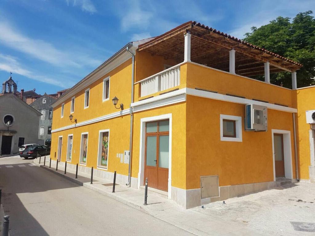 a yellow building on the side of a street at Old town apartment Popovic in Vrsar