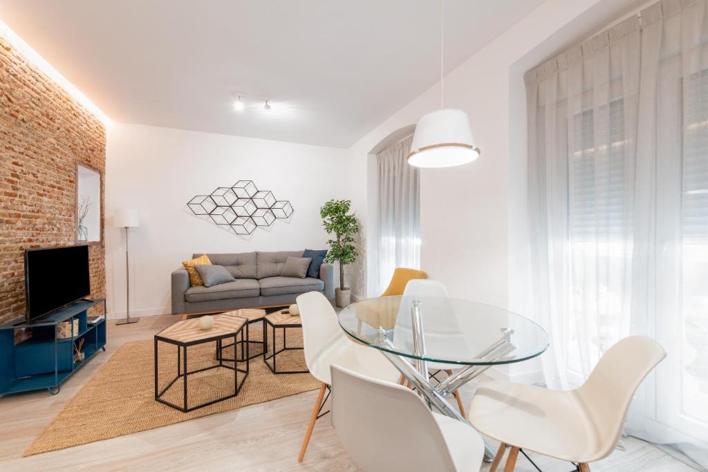 sala de estar con mesa de cristal y sillas blancas en Bright and modern- 2 bedrooms 1bathroom- MintyStay - Bocángel, en Madrid