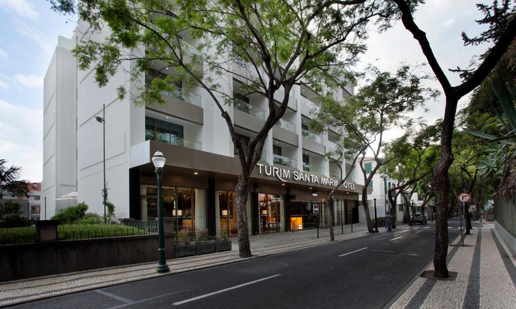 a city street with tall buildings and trees at TURIM Santa Maria Hotel in Funchal