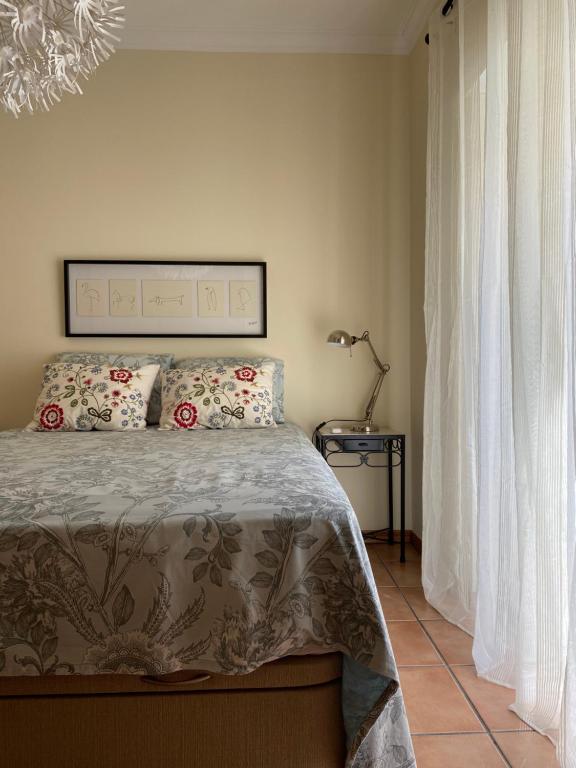 um quarto com uma cama com duas almofadas em Poço do Bispo 28 em Tavira