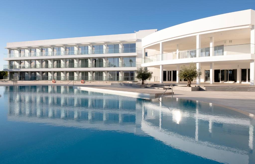 un edificio con piscina frente a un edificio en Gran Sagitario en Ciutadella