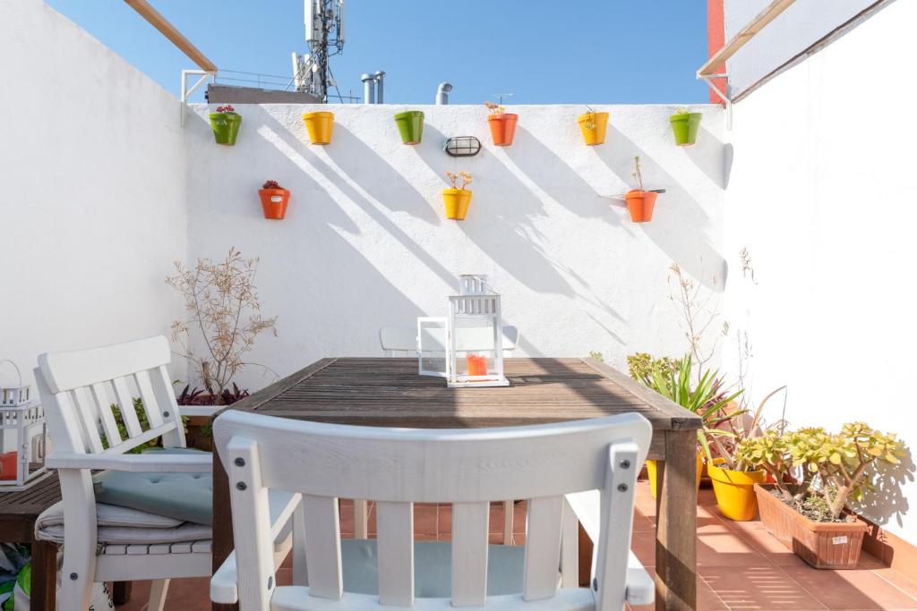 einen Holztisch und Stühle auf einer Terrasse mit Pflanzen in der Unterkunft MintyStay - Hernán Cortés in Madrid