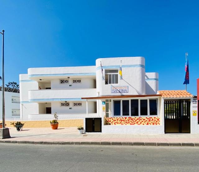 un bâtiment blanc au bord d'une rue dans l'établissement Apartamentos Sandra, à Playa del Ingles