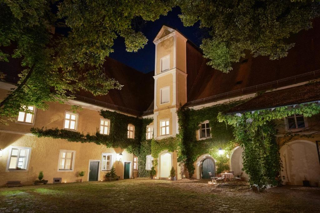 un edificio con una torre de reloj por la noche en Klosterhof St. Salvator en Bad Griesbach