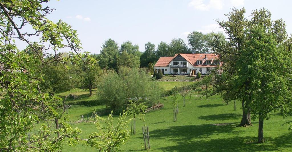 une maison au sommet d'un champ verdoyant avec des arbres dans l'établissement Buitenverblijf 't Herfse, à Malines