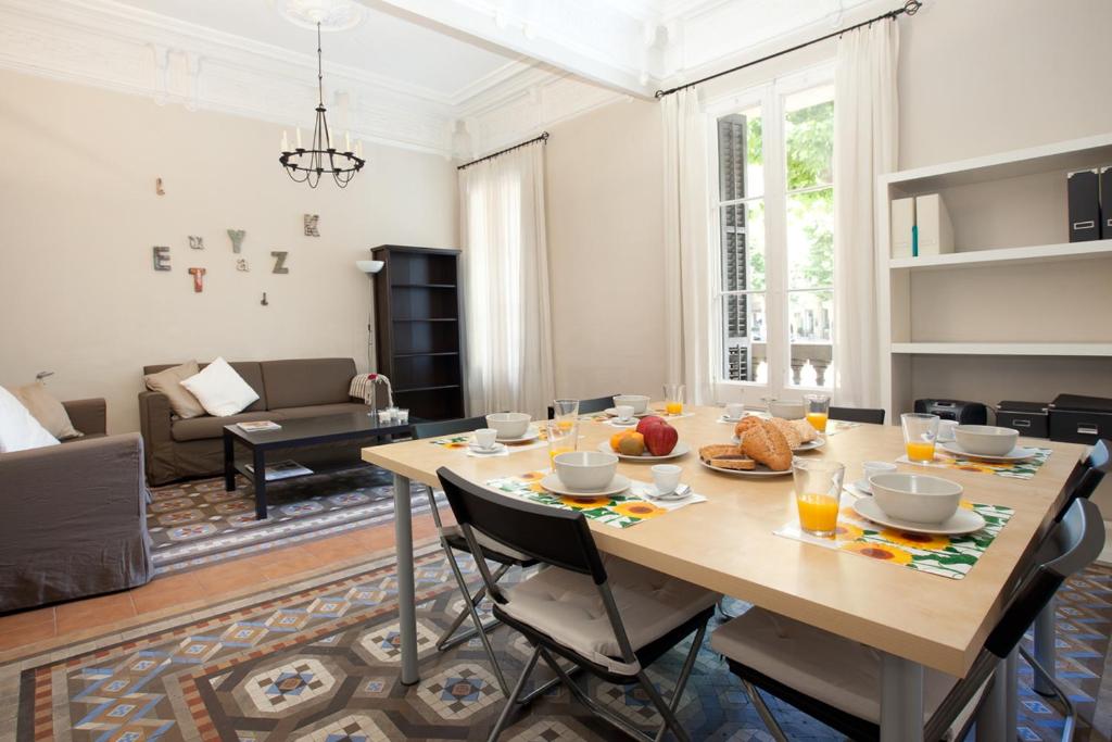 comedor y sala de estar con mesa y sillas en Modernist Apartment Barcelona, en Barcelona