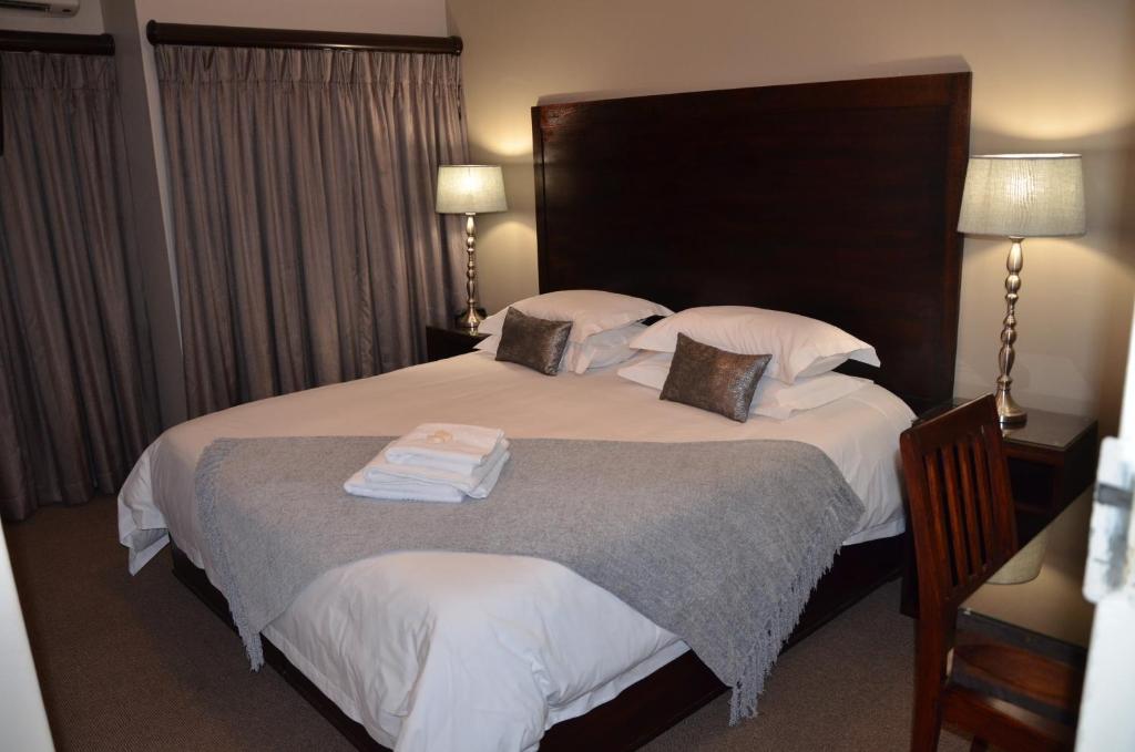 Una habitación de hotel con una cama con toallas. en Hydro Guesthouse, en Bloemfontein
