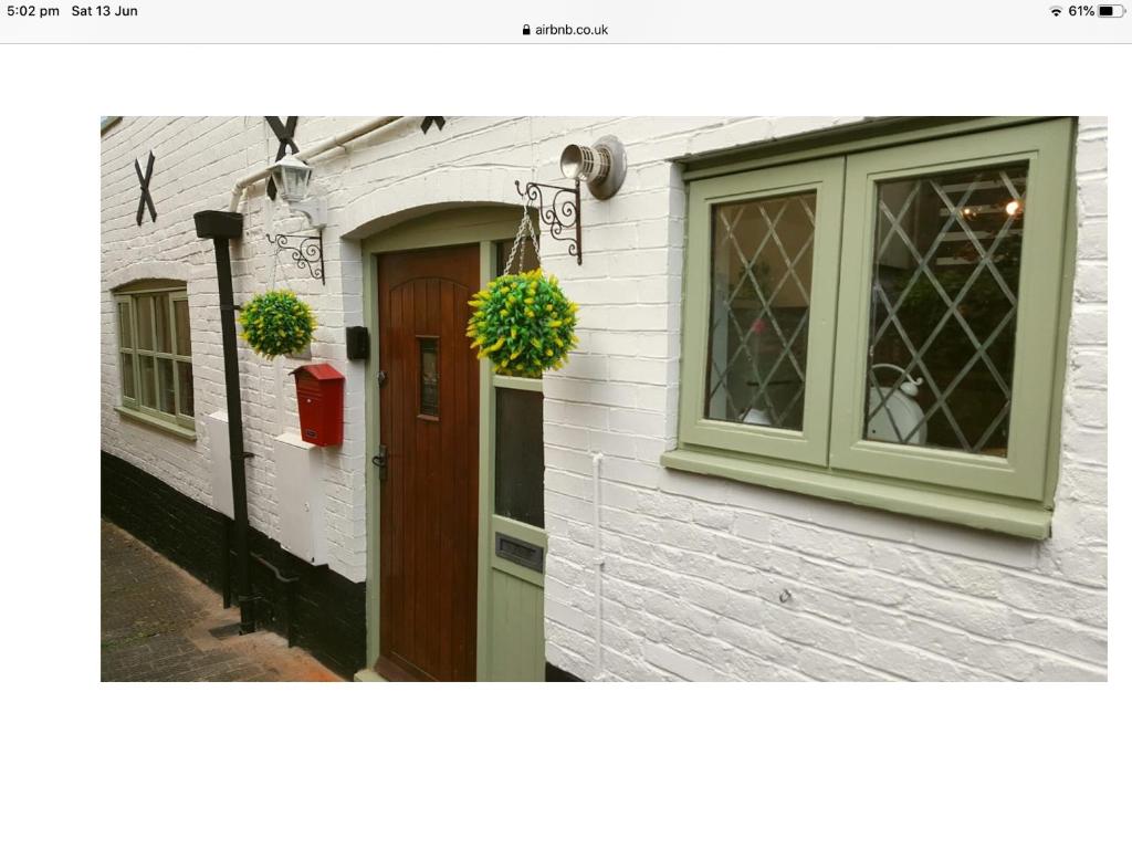 een wit gebouw met een deur en een raam bij 1 The Mews Cottages in Ledbury